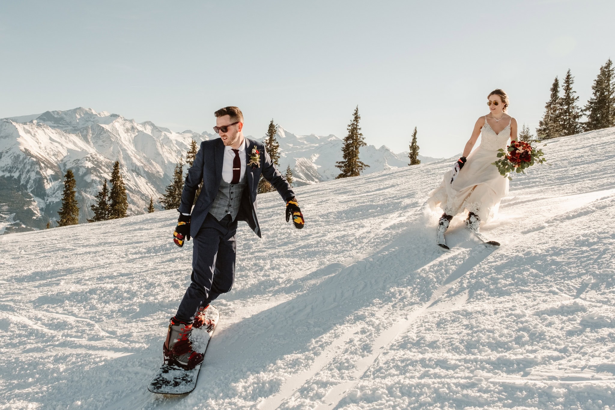 image of a bride skiing and groom snowboarding.